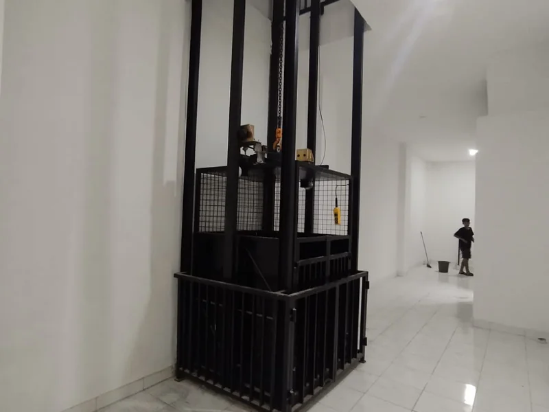 Lift barang custom terpasang di ruko grosir Jl. Perniagaan Jakarta Utara, tampak unit lengkap dengan rangka baja hitam dan guard rail